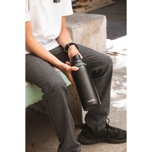 Botella Térmica Porter Flask Acero Inoxidable 700 ml — persona sentada sosteniendo la botella negra